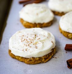 several cookies with white frosting and cinnamon sticks