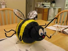 a paper mache bee sitting on top of a table