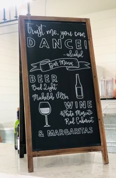 a chalkboard sign with different types of wine and margaritas on it in a kitchen