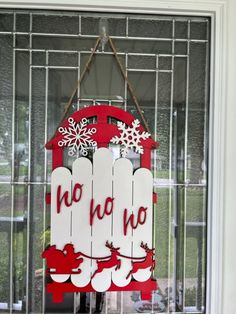 a red and white sign hanging from the side of a window with snowflakes on it