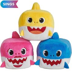 three small stuffed animals with big eyes and teeth, one in the shape of a shark