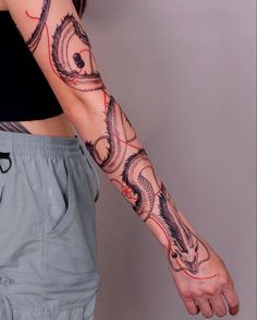 a woman's arm with tattoos on it and a dragon tattoo on the wrist