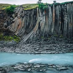 a large rock formation next to a body of water