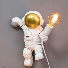 an astronaut doll is holding a light bulb