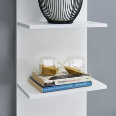 two books are stacked on top of each other in front of a black and white vase