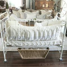 a white metal bed frame in a living room with lots of pillows on top of it