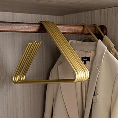 a coat rack with clothes hanging from it's sides and two coats on hangers