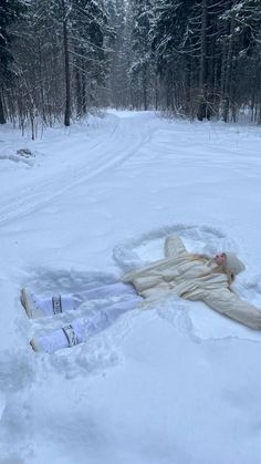 a person laying in the snow on top of a blanket