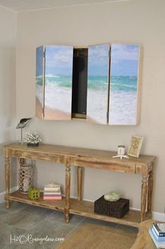 a living room with two paintings on the wall and a table in front of it