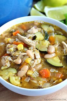 a white bowl filled with chicken and vegetable soup