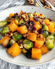 a white bowl filled with brussel sprouts and squash