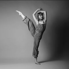 a woman in overalls doing a handstand