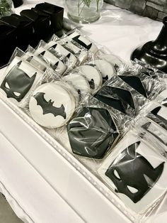 decorated cookies in the shape of batman's are on display at a bat themed party