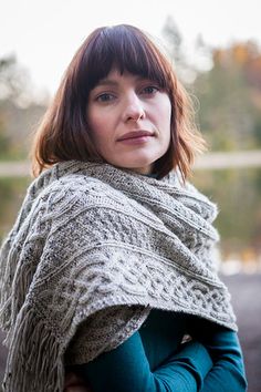 a woman wearing a knitted shawl with fringes