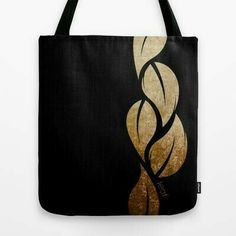 a black and gold tote bag with an abstract swirl design on it's side