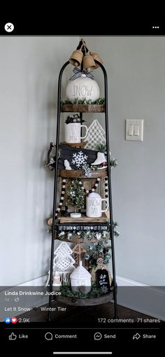 a christmas tree with white and black decorations on it's sides, sitting in front of a gray wall