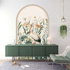 a living room with green furniture and flowers on the wall, along with a bird mural