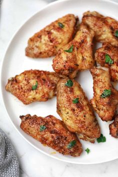 chicken wings on a white plate with parsley