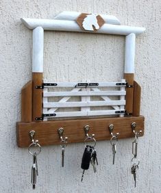 a wooden key rack with keys hanging from it's hooks on the side of a wall