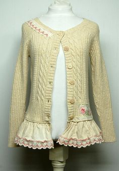 a white mannequin wearing a cream colored cardigan