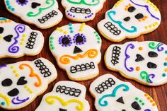 decorated sugar cookies in the shape of skulls on a wooden table with colorful icing