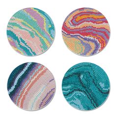 four coasters with different colors and designs on the top one is blue, green, pink