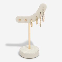 a pair of earrings on a white stand