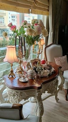 a dining room table with flowers and tea cups on it