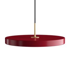 a red table with an umbrella on it and a black pole sticking out of the top