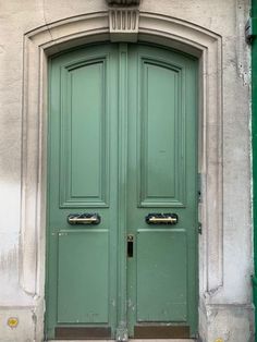 two green doors are open in front of a building