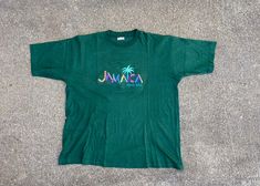 "Vintage Forest green large 100% cotton embroidered T-shirt. Reggae Tees tag.  \"Jamaica\" with a palm tree and Ocho Rios embroidered across the front.  Excellent condition  Chest 25 length 29 All items are previously owned and may show signs of wear and tear. Please look at all pictures carefully. Feel free to ask any questions. Thank you." Embroidered Green Tops For Streetwear, Green Tropical Crew Neck Top, Green Tropical Cotton Tops, Green Casual T-shirt With Embroidered Text, Casual Green T-shirt With Embroidered Text, Green T-shirt With Embroidered Graphics, Green Embroidered Graphics T-shirt, Green Short Sleeve T-shirt With Embroidered Text, Retro Green Pre-shrunk T-shirt