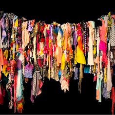 a bunch of clothes that are hanging on a line together in front of a black background