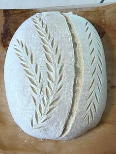 two round white breads sitting on top of a wooden cutting board next to each other