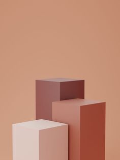 three different colored cubes on a pink background