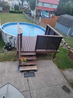 an above ground swimming pool with steps leading up to it and a deck in the middle