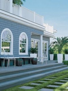 a house with steps leading up to the front door, and potted plants on either side