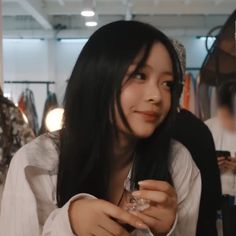 a woman sitting at a table with a glass in her hand