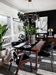 a black and white dining room with potted plants