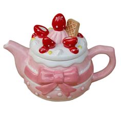 a pink teapot with an ice cream sundae on it's top and a bow tie around the neck