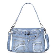 a blue purse with holes and chains on the front, sitting on a white surface