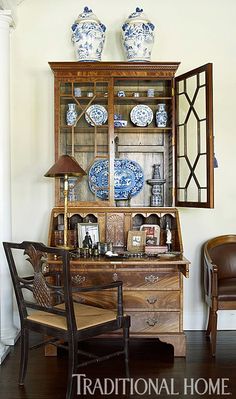 an antique china cabinet with blue and white plates on it