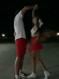 a man and woman on skateboards in the dark