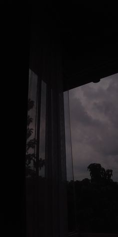 the window is open and there are dark clouds in the sky