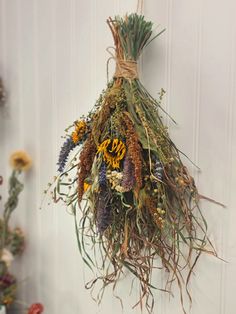 You will receive this exact Hanging Fall Bouquet. Great for your door or in the kitchen. This Autumn Besom has dried sunflowers, bronze amaranth, yellow flax pods, indigo hyssop herb flowers and grasses. The grasses hang down 15 inches but the bulk of the bouquet is about 13 inches long. It's about 9 inches across and sticks out from the wall about 4.5 inches. Herb Flowers, Dried Sunflowers, Fall Bouquet, Amaranth, Dried Flower Arrangements, Grasses, The Kitchen, Flower Arrangements