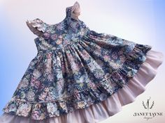 This lovely garden party dress is perfect for summer into fall!  It's made from a beautiful 100% cotton floral print.  The blue floral is accented with a soft peach fabric (Imperial broadcloth 60% polyester/40% cotton) that is featured on the flutter sleeves, back sash, and underskirt.  Both the top skirt and full underskirt have self-fabric ruffles and peach piping is used to accent the top skirt ruffle.  The dress closes with peach buttons and is cut to above-knee length (23 inches shoulder-to-hem for size 5).  If you would like this dress in a different size, please let me know. Materials 100% Cotton Imperial broadcloth (60% polyester/40% cotton) Mini-piping Buttons Cottagecore Floral Dress With Ruffles For Garden Party, Cotton Cottagecore Floral Dress For Garden Party, Cottagecore Floral Cotton Dress For Garden Party, Cotton Floral Dress With Ditsy Print For Garden Party, Cottagecore Cotton Floral Dress For Garden Party, Spring Cotton Dress For Tea Party, Summer Floral Print Dress For Tea Party, Summer Tea Party Dress With Floral Print, Cotton Dress For Spring Tea Party