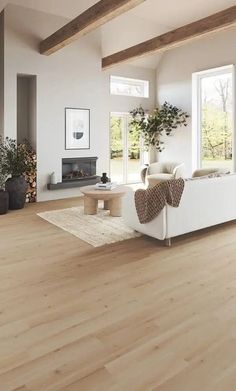 a living room with white furniture and wood floors