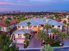 an aerial view of a large home with palm trees