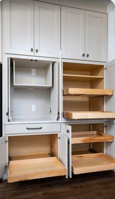 an empty kitchen with white cabinets and wooden shelves