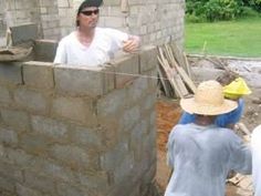 two men are working on a brick wall