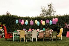 a group of chairs sitting around a table covered in colorful paper lanterns and streamers